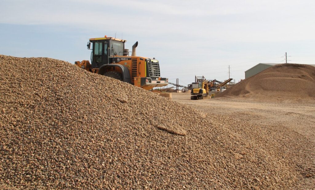 a large pile of dirt next to a bulldozer